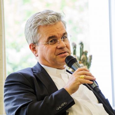 Erzbischof Bentz im Gespräch mit Mikrofon in der Hand