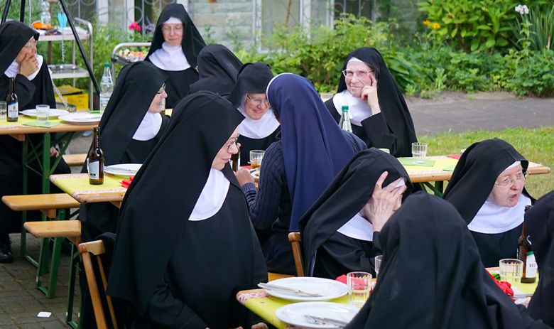 Schwestern am Tisch im Garten beim Grillabend